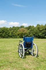 Fototapeta na wymiar 緑の芝生に置かれた無人の車椅子