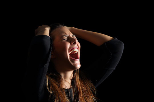 Depressed woman crying and shouting desperate in black