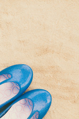 Fototapeta na wymiar Close-up woman shoes put on sand at the beach.