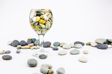 Glass with ocean rocks on white background