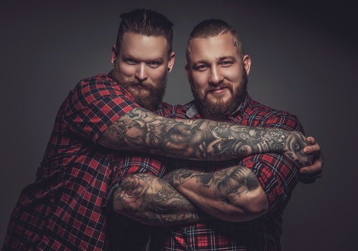 Two smiling friends with beards and tattooes