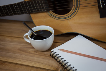 coffee cup and guitar on wooden table