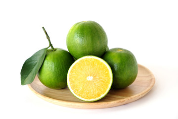 Whole and half sweet oranges on round wooden tray