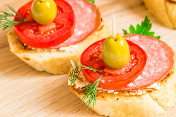 Tasty appetizer with sausage, tomatoes and olives