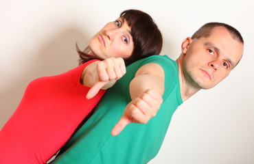 Unhappy woman and man showing thumbs down