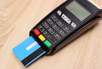 Payment terminal with credit card on desk, finance concept