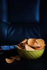 potato chips in bowl on sofa at night