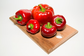 Many ripe red peppers on over white