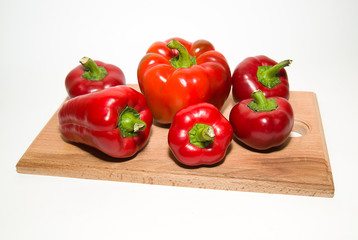Many ripe red peppers on over white