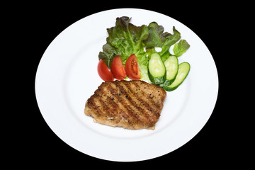 photo of a pork stake on a white plate with a cucumber, tomato a
