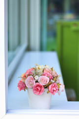 Stock Photo:.Bouquet of artificial flowers in a window to look t