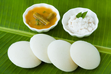Indian idly with chutney and sambar - Fresh steamed Indian Idly (Idli / rice cake) arranged on a...