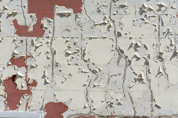 Flaking white paint on brick wall