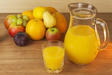 Domestic fresh orange juice in a glass jar on a wooden table. Hand-prepared homemade orange juice. Healthy drink for athletes. Place for your text. Sales of juices.

