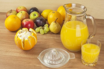 Domestic fresh orange juice in a glass jar on a wooden table. Hand-prepared homemade orange juice. Healthy drink for athletes. Place for your text. Sales of juices.

