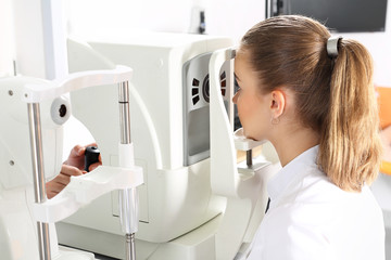 Komputerowe badanie ostrości wzroku. Pacjentka podczas badanie wzroku w klinice okulistycznej  - obrazy, fototapety, plakaty