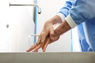 Chirurg myje dłonie 
Lekarz myje ręce, dezynfekuje ręce przed rozpoczęciem operacji - obrazy, fototapety, plakaty