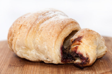 Puff pastry with fruit jam on the wooden board
