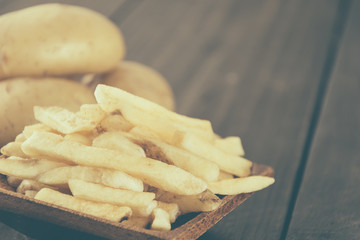 french fries on wood background - soft focus with vintage film f