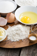 prepared baking ingredients on a wooden board, vertical