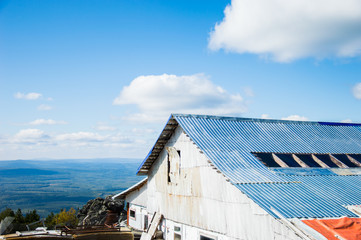 Fototapeta premium белое Здание с синей крышей на фоне леса