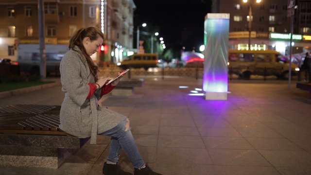 A young woman  in the square and using digital tablet.