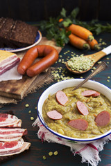 Traditional Dutch pea soup and ingredients on a rustic table - 92066694
