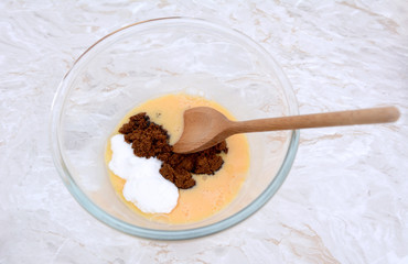 Stirring caster and muscovado sugar into beaten egg