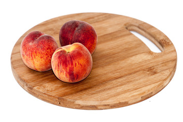 Fresh peaches on the kitchen wooden board