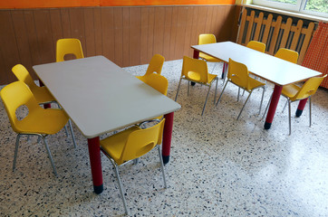 kindergarten classroom with desks and yellow chairs
