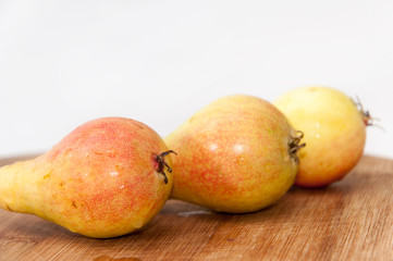 Three fresh pears on the wooden board