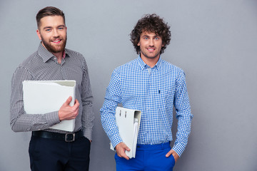 Portrait of a two casual businessmen holding folders