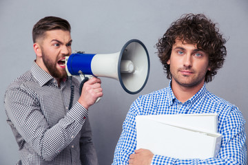 Businessman yelling via megaphone to another man