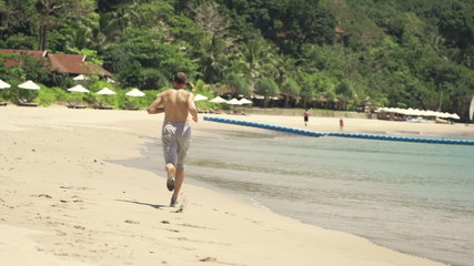 Young man running on the beach, super slow motion, shot at 240fps
