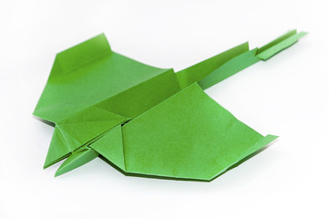 Green origami airplane over white background