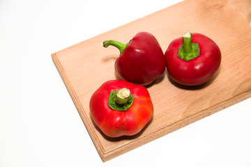 Three ripe red peppers on over white