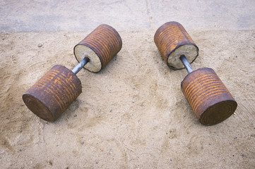 Homemade Brazilian dumbbell weights made from concrete inside rusted food cans at an outdoor gym at Arpoador Beach, Rio de Janeiro, Brazil