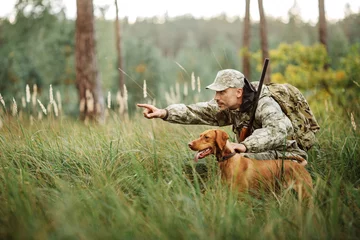 Abwaschbare Fototapete Jagd Yang Hunter mit Gewehr und Hund im Wald