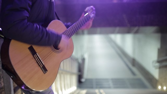 Close-up guitar. Man playing in the underground passage
