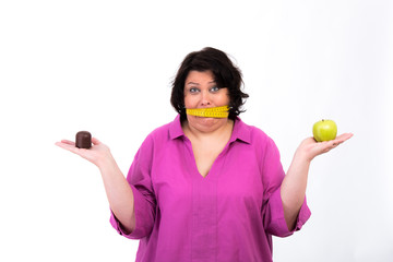 übergewichtige frau mit schokokuss und apfel