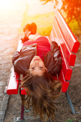 ng girl lying on a red bench with long hair back