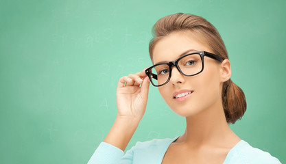 happy teenage student girl or woman in eyeglasses - obrazy, fototapety, plakaty