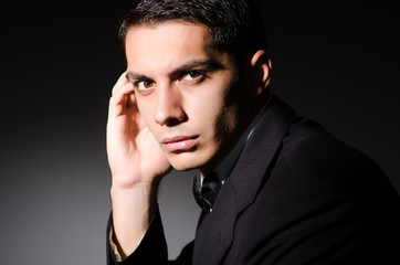 Young businessman in dark studio