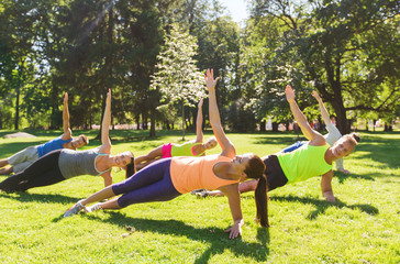 group of happy friends exercising outdoors