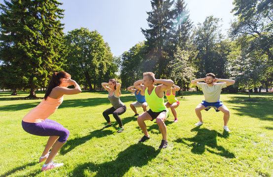 group of happy friends exercising outdoors