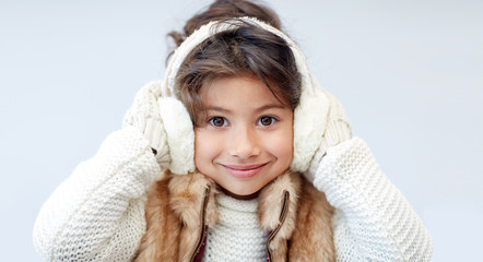 happy little girl wearing earmuffs - obrazy, fototapety, plakaty