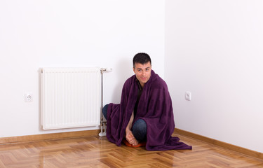 Man with blanket beside heater