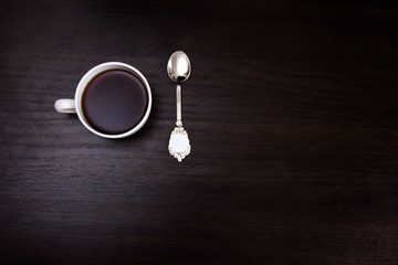espresso coffee cup on a table of dark wood. Beautiful vintage spoon