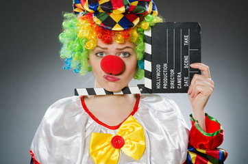 Clown with movie clapper in funny concept