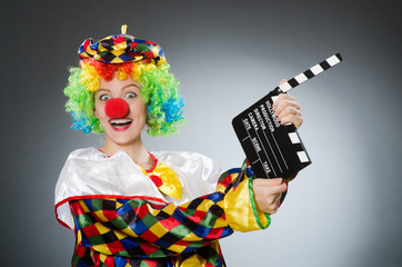 Clown with movie clapper in funny concept